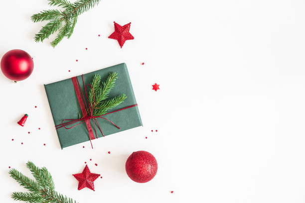 istock Christmas composition. Gift, fir tree branches, red decorations on white background. Christmas, winter, new year concept. Flat lay, top view, copy space 1058026028