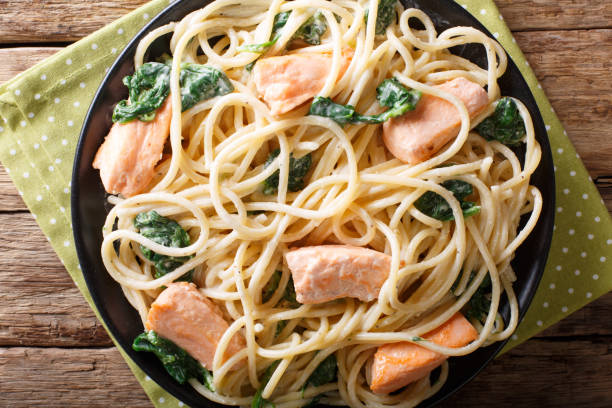 istock Italian cuisine: spaghetti with salmon, cream cheese and spinach close-up on plate. horizontal top view 1058027788