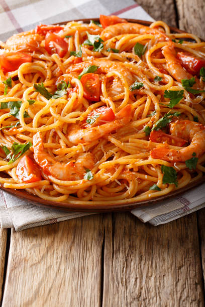 istock spaghetti with shrimps with diavolo sauce close-up on a plate. vertical 1058027836