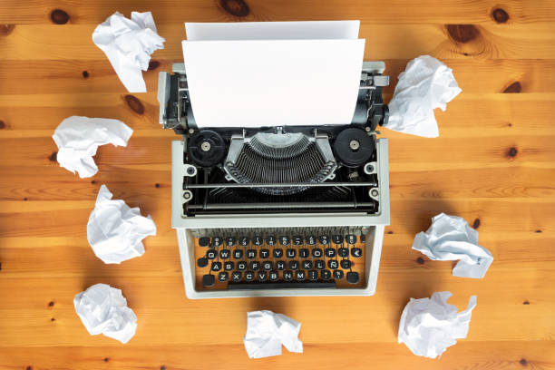istock Writer's block. Typewriter and crumpled paper on work desk. Creative process concept 1058027888
