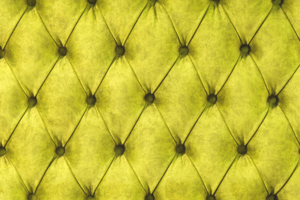 istock Velor surface of sofa close-up. Training equipment-velor mats tightened with buttons. Yellow chesterfield style quilted upholstery background close up 1058029538