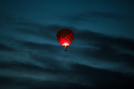 A glowing hot air balloon in the early morning sky