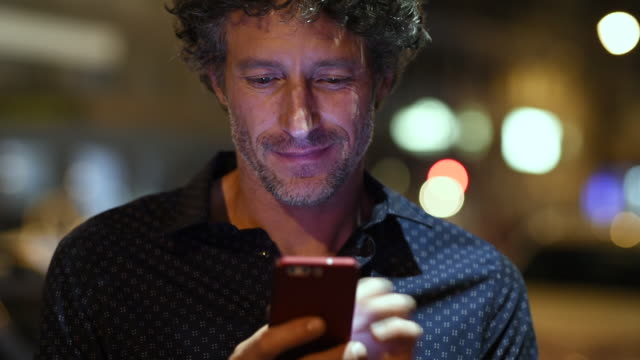 Man checking smartphone at night