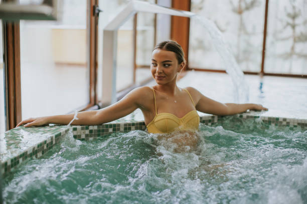 istock Pretty young woman relaxing in the bubble bath pool 1058041396
