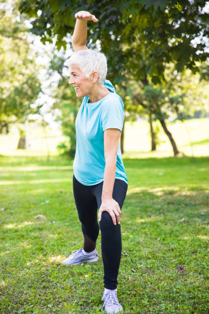 istock Senior woman doing streching exercise in the park 1058041958