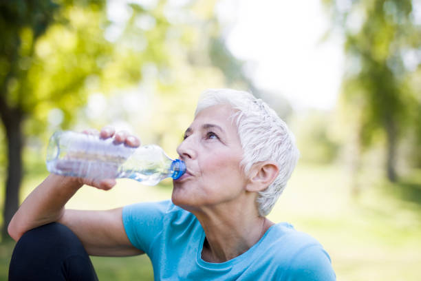 istock Senior woman rests and drinks water after workout 1058042010