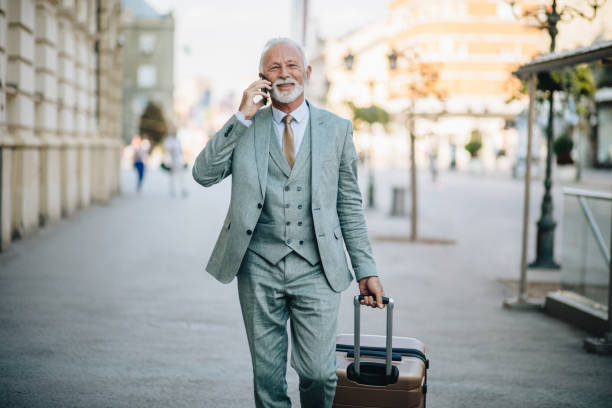 istock Smiling senior businessman talking while on a business travel 1058042390