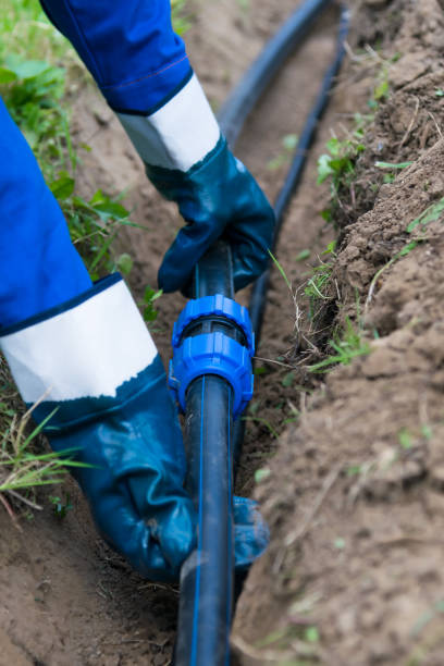 istock hands hold black pipe before laying in the ground 1058043838