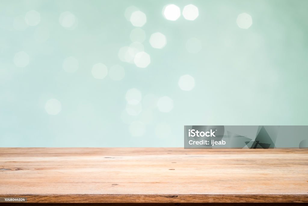 Wooden table with mint  bokeh abstract background. Wood table top on mint  bokeh abstract background and used for montage or display products. Backgrounds Stock Photo