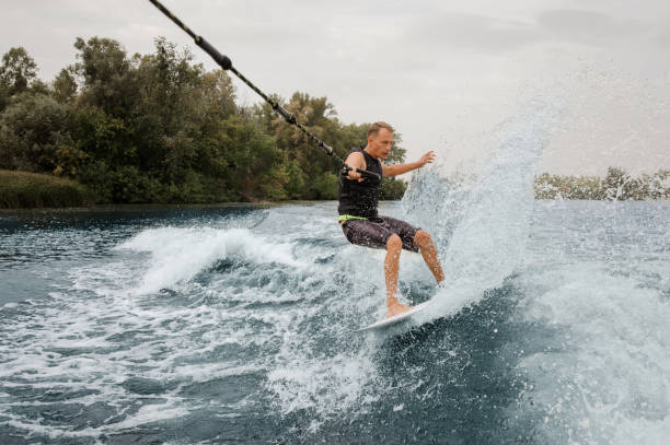 istock Active man riding on the wakeboard holding a rope 1058044468