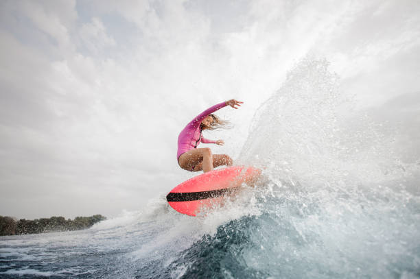 istock Active girl jumping on the orange wakeboard 1058044786
