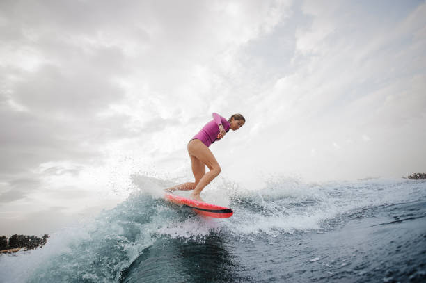 istock Active slim girl riding on the orange wakeboard 1058045042