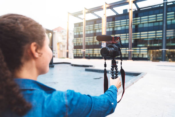istock Young woman holding camera outdoors 1058045130