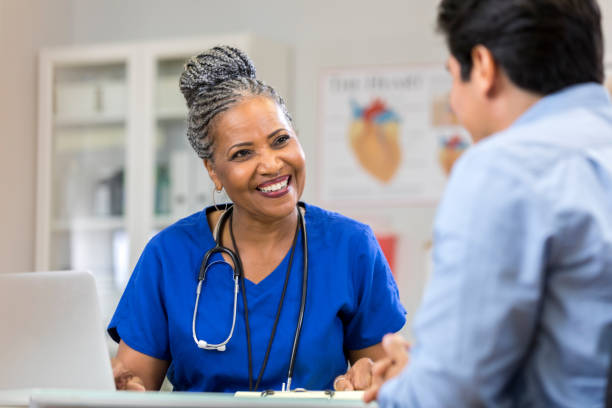 istock Cheerful nurse laughs with unrecognizable patient 1058047746