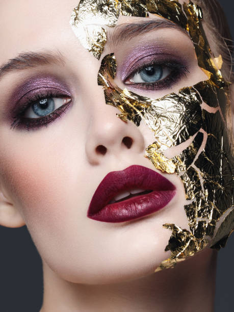 Skin care treatment with golden foil Studio portrait of beautiful woman with bright make-up and golden foil crazy makeup stock pictures, royalty-free photos & images