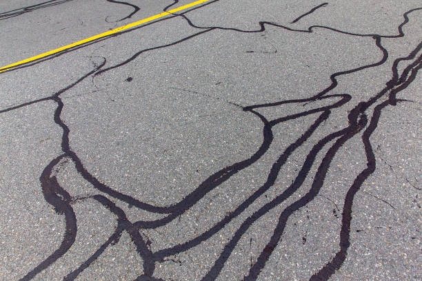 asphalt road with filled cracks - concrete driveway cement construction imagens e fotografias de stock