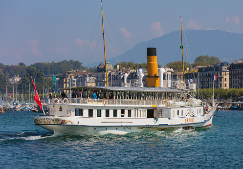 Geneva, Switzerland - September 24, 2016: the Savoie ship passing on Lake Geneva with passengers on board, view from the city of Geneva. The Savoie was built in 1914 and restored to its former Belle Epoque splendour in 2006, it used for cruises on Lake Geneva.