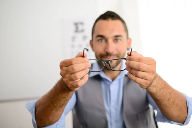 istock handsome young male optician handing optical eye glasses on white background 1058060312