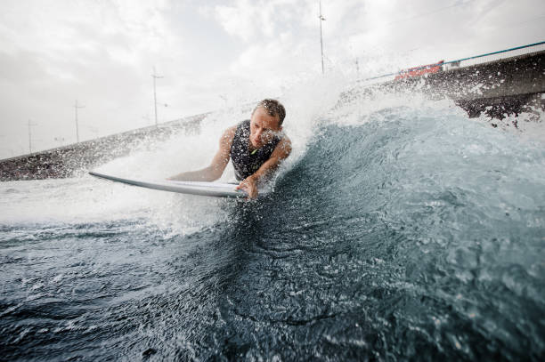 istock Wakesurfer lying on white board and swimming down the river against the bridge 1058060372