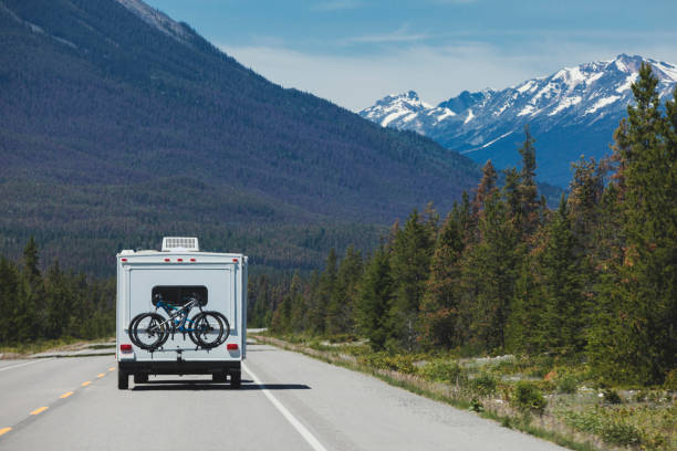 rv dans les montagnes rocheuses canadiennes du parc national banff, alberta, canada - driving motor home forest banff national park photos et images de collection