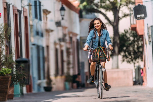 자전거 타고 출퇴근 하는 젊은 여자 - queretaro city 뉴스 사진 이미지