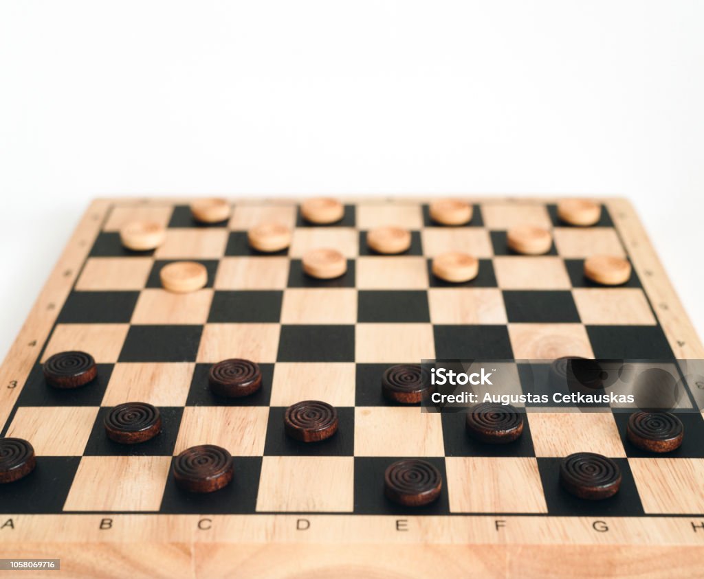 wooden checkerboard with checkers spaced isolated on white Activity Stock Photo