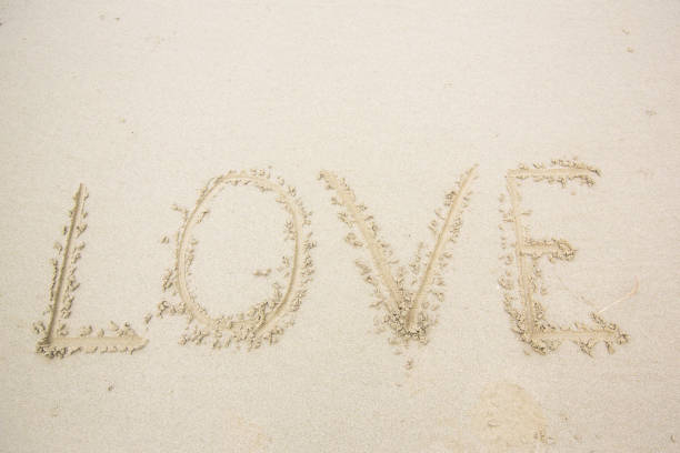 istock writing love on sand. love message written in sand 1058084156