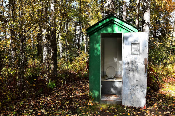 An image of an old wooden outhouse in a camp ground.