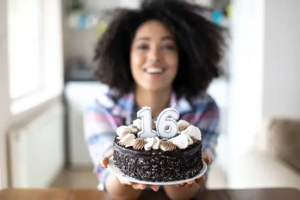 Photo of Smiling woman offering a birthday cake