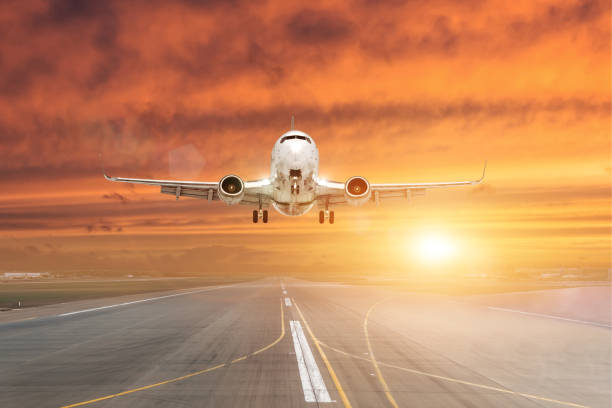 istock Passenger airplane landing at sunset on a runway. 1058093462