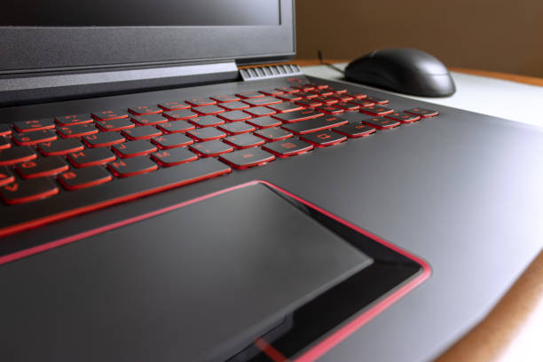 istock Game laptop with red colored keyboard and a mouse on background 1058093968