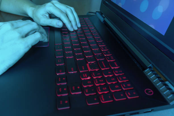 istock Hands tiping on laptop keyboard at night in display blue light 1058093988