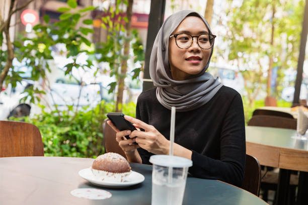 istock Young Woman in Kuala Lumpur Sidewalk Cafe 1058094666