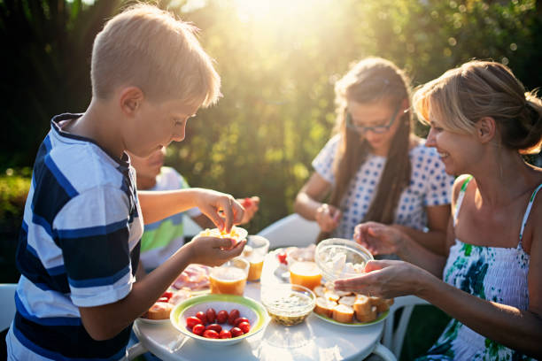 family eating fresh breakfast outdoors - breakfast eating people teens imagens e fotografias de stock