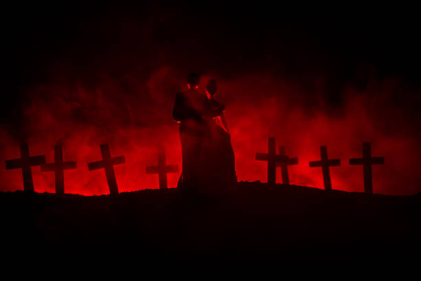 istock Halloween. Scary zombie bride on a night cemetery holds a pumpkin lantern. 1058099850