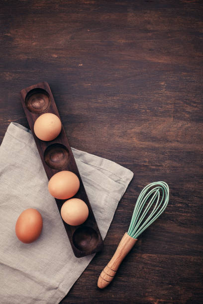 istock Brown chicken eggs in the wooden egg stand over the rustic backg 1058100590