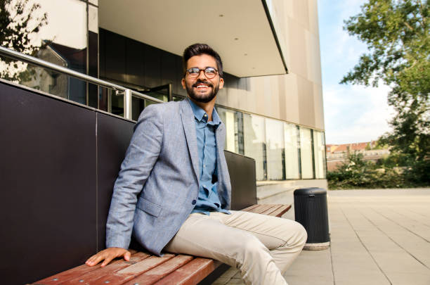 istock Handsome, elegant bearded man in suit sitting on bench 1058105374