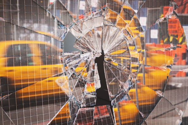 A New York City taxi is reflected in a cracked door window.