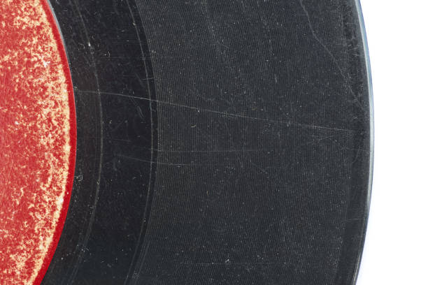 Red and black 45 music record with scratches An detail of an old scratched 45 record isolated on white. grooved stock pictures, royalty-free photos & images