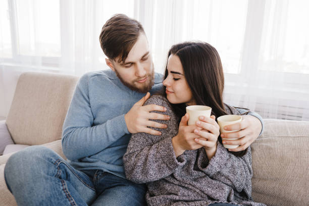 istock Young couple relaxing at home with hot drinks 1058109822