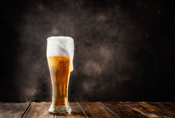 bicchiere di birra fresca e fredda su sfondo scuro - birra foto e immagini stock