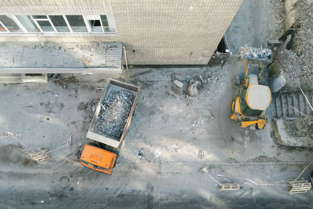istock Bulldozer loader uploading waste and debris into dump truck at construction site. building dismantling and construction waste disposal service. Aerial drone industrial background 1058118364