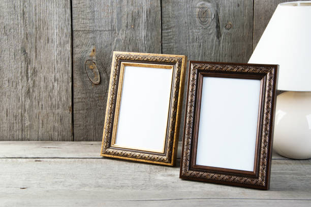 istock Two empty picture frames on wooden background. 1058119506