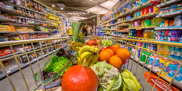 Healthy Fruit and vegetables in Grocery shop cart in supermarket filled with food products as seen from the customers point of view