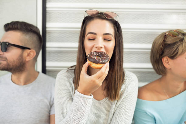 istock Young woman eating a donut 1058121834