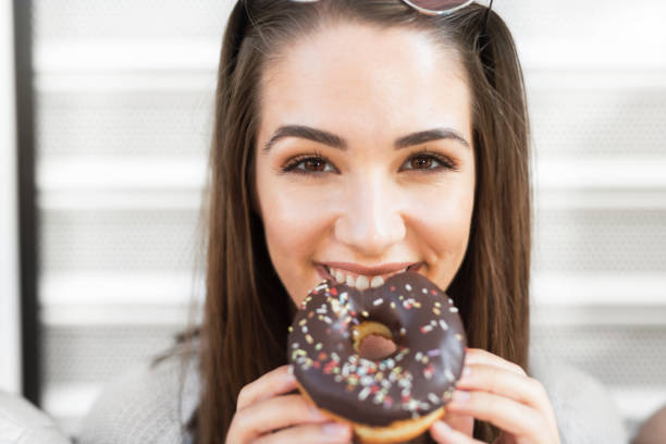 istock Beautiful young woman eating a donut 1058121946