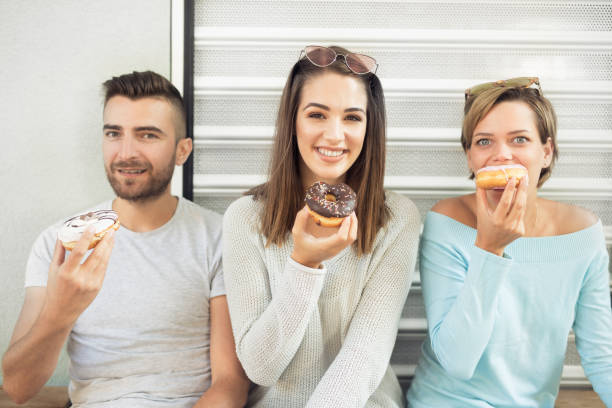 istock Group of friends eating donuts 1058122106