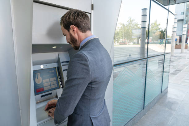 istock Happy man making a cash withdrawal at an ATM 1058123492