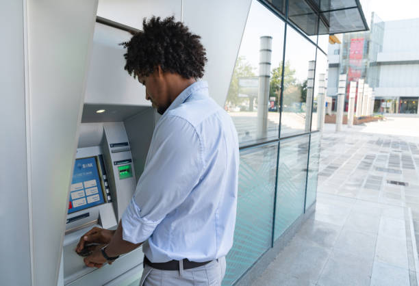 istock Happy man making a cash withdrawal at an ATM 1058123524