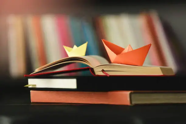 Photo of Paper Boat At Edge Of Book